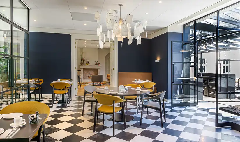 Een kamer met tafels en stoelen en een kroonluchter aan het plafond